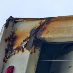 A truck corner that is rusted through