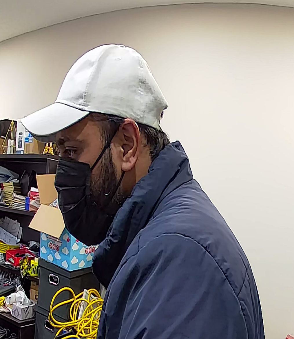 Brown male, black mask, white ball cap, blue jacket