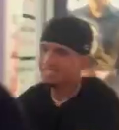 male wearing a black hate and black t-shirt