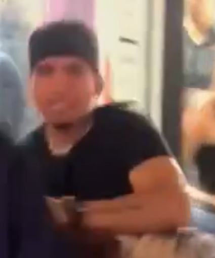 male wearing a black hate and black t-shirt