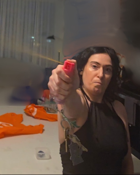 A person holding a pink spray object