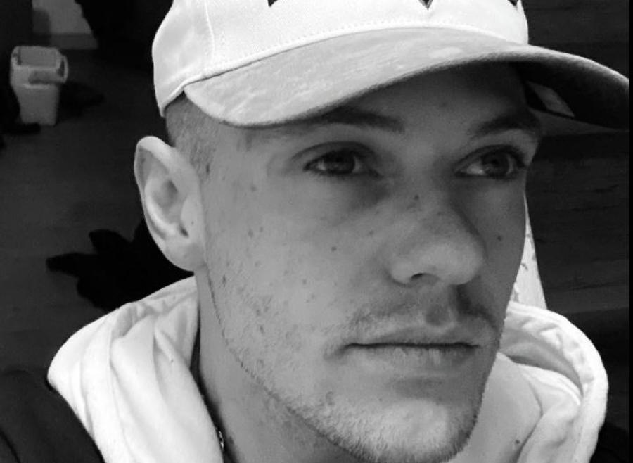 White male wearing a Toronto Raptors ballcap and a hooded jacket