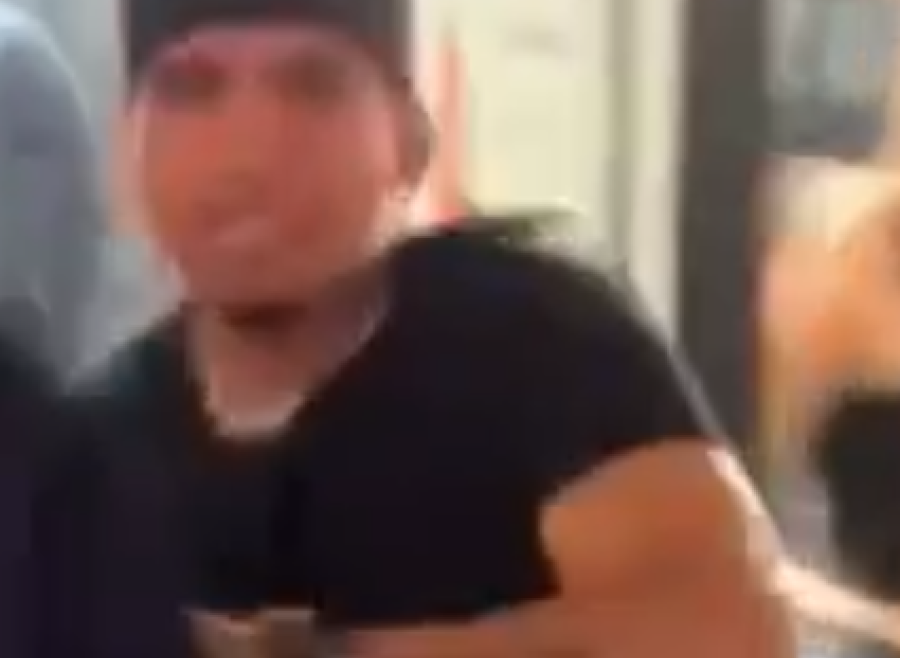 male wearing a black hate and black t-shirt