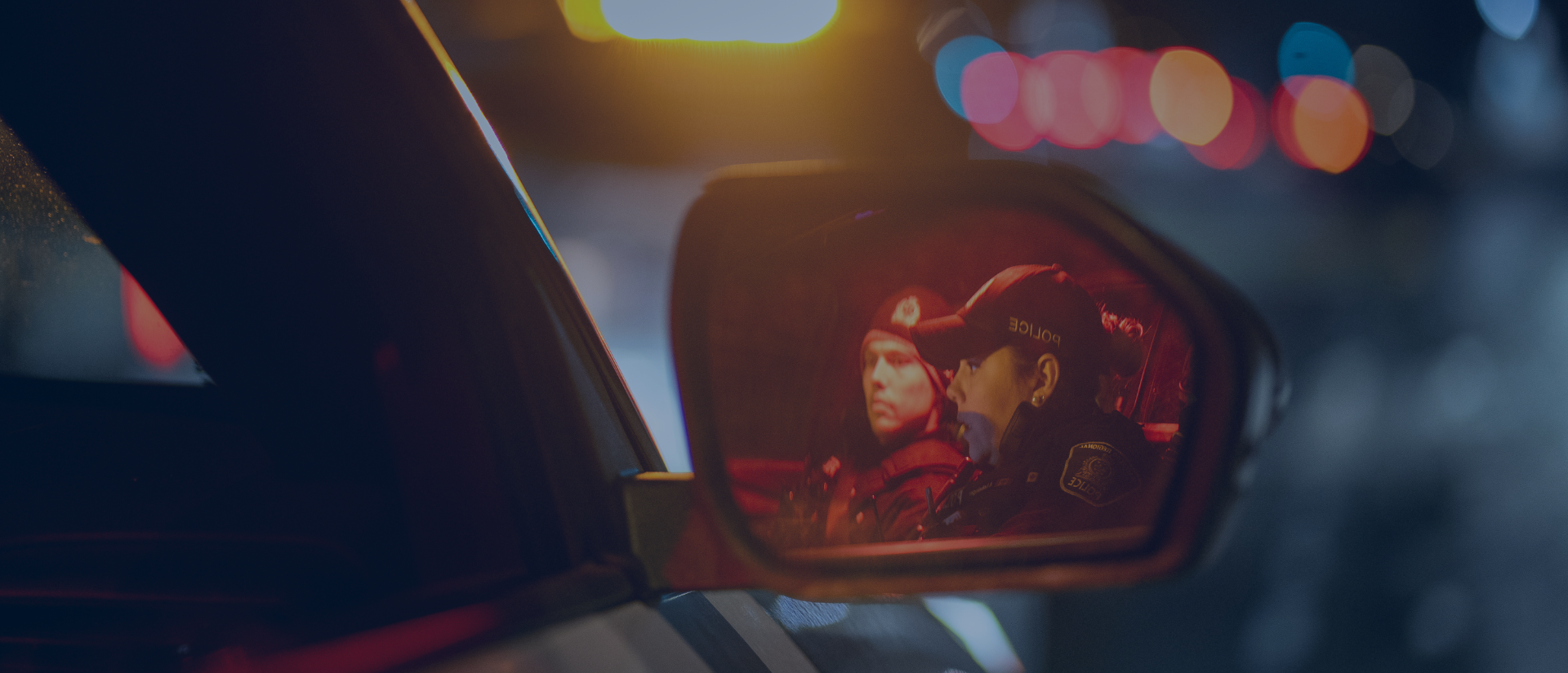 Officer in cruiser mirror. 