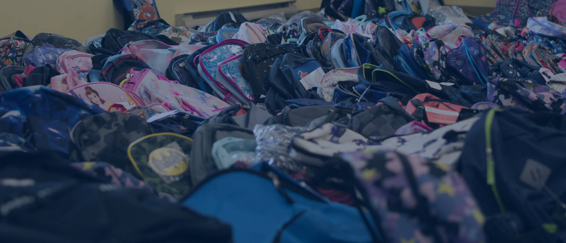 A large pile of donated backpacks