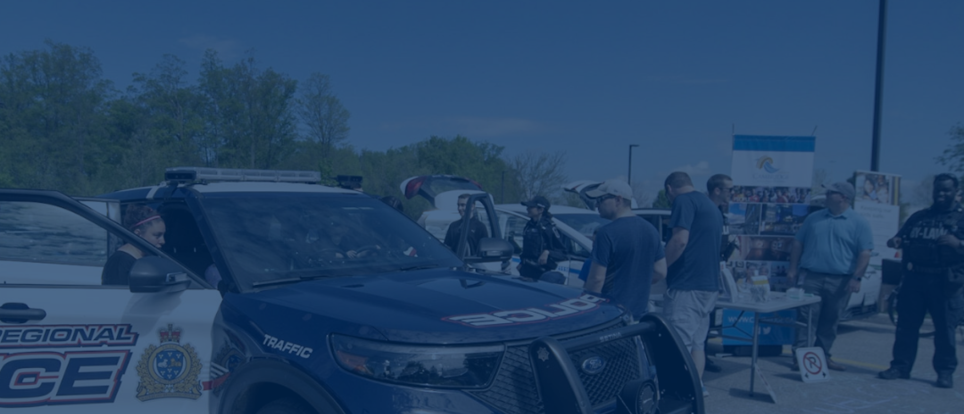 A police cruiser and people standing around in the background