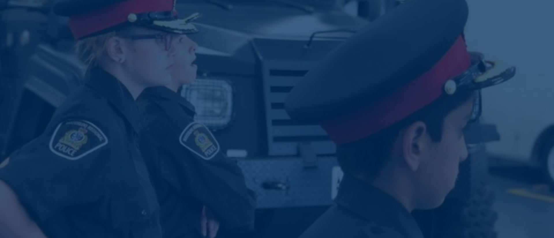 Three children standing by a police vehicle